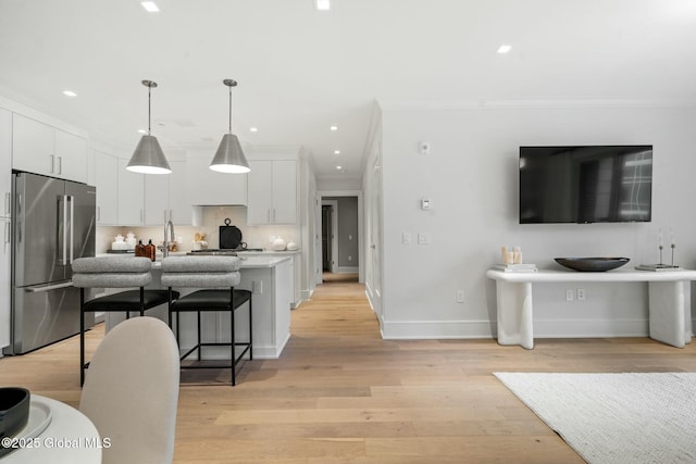 19 Washington St Unit 552P, Saratoga Springs, Inside, NY 12866 - kitchen with high end refrigerator, crown molding, a kitchen bar, white cabinets, and light countertops