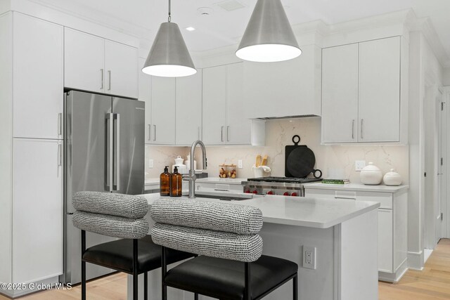 19 Washington St Unit 552P, Saratoga Springs, Inside, NY 12866 - kitchen with freestanding refrigerator, light countertops, a kitchen breakfast bar, light wood-style floors, and decorative backsplash