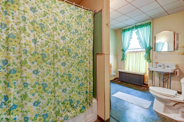 61 Mohawk St, Fort Plain, NY 13339 - bathroom featuring radiator, tile walls, shower / bathtub combination with curtain, and a wainscoted wall