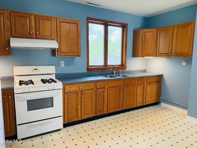 471-473 Harrison Ave, Schenectady, NY 12306 - kitchen featuring white gas stove, under cabinet range hood, and brown cabinetry