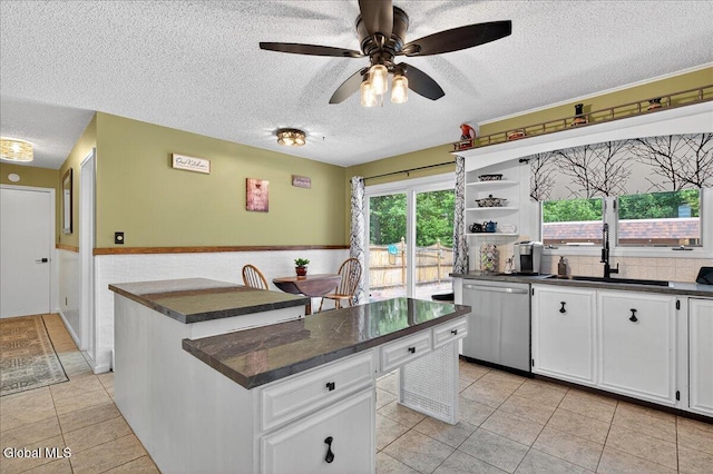 10 Heather Ln, Johnstown, NY 12078 - kitchen featuring dishwasher, dark countertops, a textured ceiling, a kitchen island, and light tile patterned floors