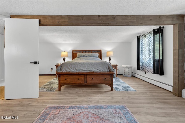 10 Heather Ln, Johnstown, NY 12078 - bedroom with baseboard heating, a textured ceiling, and wood finished floors