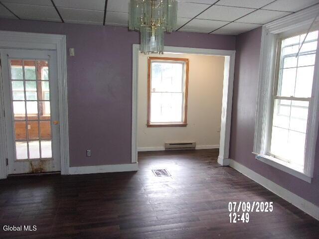 20 N 4th Ave, Ilion, NY 13357 - unfurnished dining area featuring a baseboard heating unit, plenty of natural light, a drop ceiling, wood finished floors, and a chandelier
