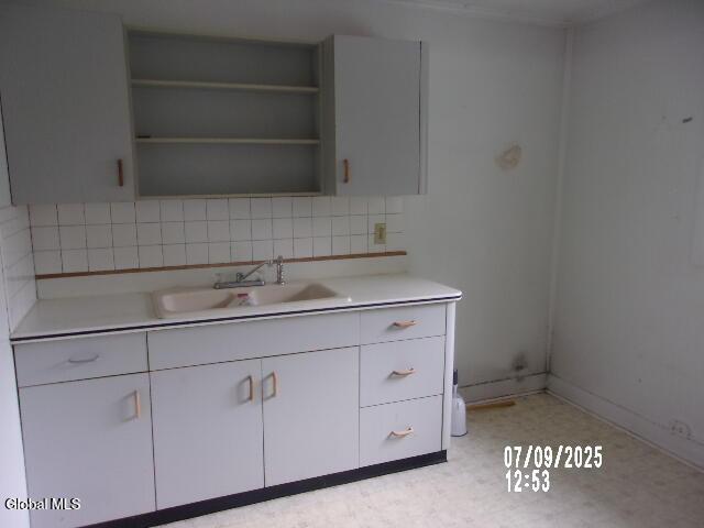 20 N 4th Ave, Ilion, NY 13357 - kitchen with light countertops, light flooring, backsplash, and white cabinets