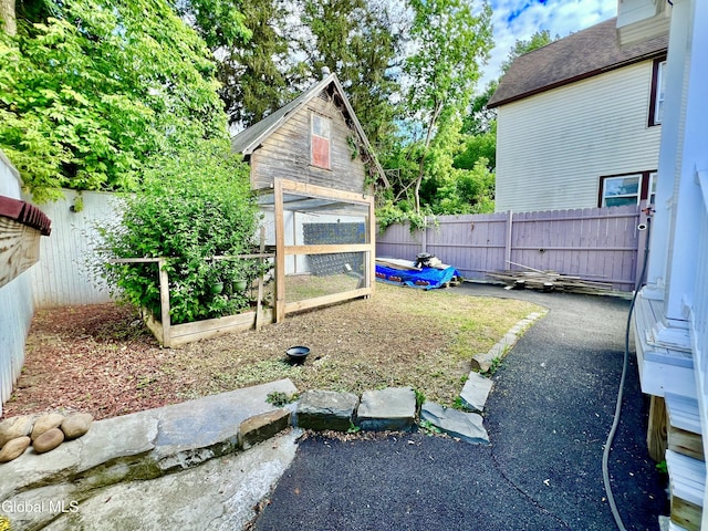 101 Prospect St, Schenectady, NY 12308 - view of side of property featuring a fenced backyard, a garden, an outbuilding, and a shingled roof