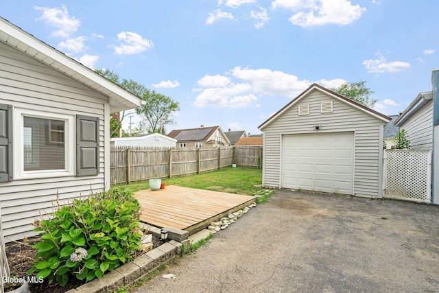407 Huston St, Scotia, NY 12302 - fenced backyard featuring a garage, a deck, asphalt driveway, and an outbuilding
