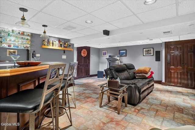 7 Marquette Ave, Colonie, NY 12110 - living room featuring a dry bar, a paneled ceiling, and light stone finish flooring