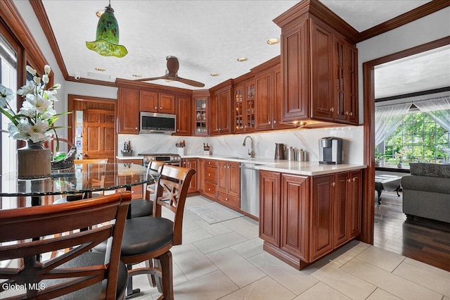 7 Marquette Ave, Colonie, NY 12110 - kitchen featuring appliances with stainless steel finishes, crown molding, glass insert cabinets, backsplash, and light countertops