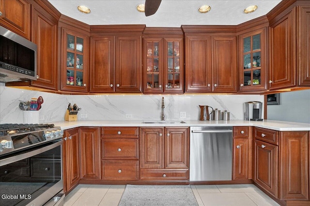 7 Marquette Ave, Colonie, NY 12110 - kitchen with appliances with stainless steel finishes, light countertops, light tile patterned floors, glass insert cabinets, and tasteful backsplash