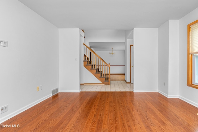 3002 Morgan Ct, Schenectady, NY 12306 - empty room featuring stairway, a chandelier, and wood finished floors
