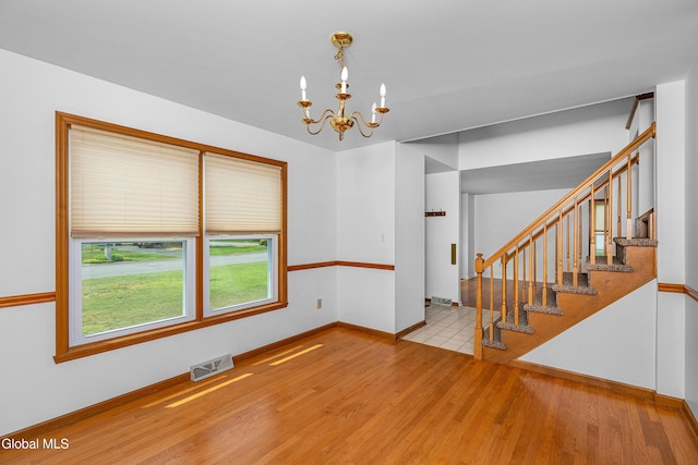 3002 Morgan Ct, Schenectady, NY 12306 - empty room with a chandelier, wood finished floors, and stairs
