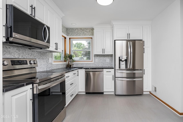 3002 Morgan Ct, Schenectady, NY 12306 - kitchen featuring stainless steel appliances, dark countertops, white cabinetry, and decorative backsplash