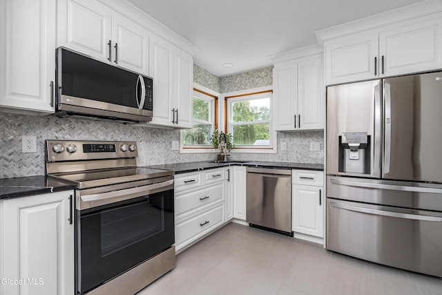 3002 Morgan Ct, Schenectady, NY 12306 - kitchen with appliances with stainless steel finishes, dark countertops, white cabinets, and decorative backsplash