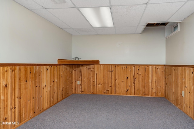 3002 Morgan Ct, Schenectady, NY 12306 - empty room featuring a drop ceiling, wood walls, carpet floors, and wainscoting