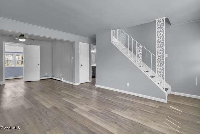 6 Briarwood Rd, Colonie, NY 12211 - unfurnished living room featuring stairs, ceiling fan, wood finished floors, a baseboard radiator, and a baseboard heating unit