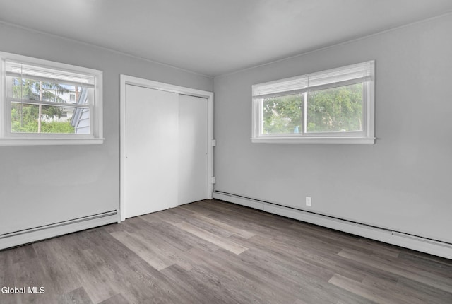 6 Briarwood Rd, Colonie, NY 12211 - unfurnished bedroom with a baseboard heating unit, a closet, and wood finished floors