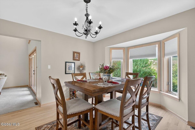 3 Pine Ridge Rd, Saratoga Springs, NY 12866 - dining area with a chandelier and light wood-style flooring