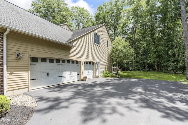 222 Bell Ct, Guilderland, NY 12303 - view of home's exterior with driveway, a shingled roof, a lawn, and brick siding
