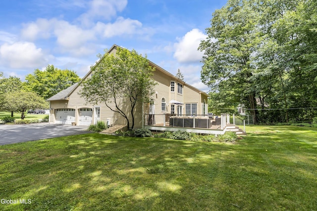 222 Bell Ct, Guilderland, NY 12303 - view of home's exterior featuring asphalt driveway, a deck, a lawn, and an attached garage
