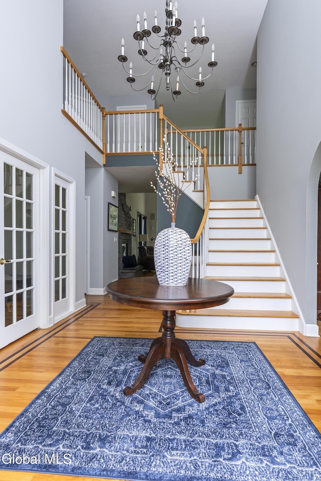 222 Bell Ct, Guilderland, NY 12303 - foyer entrance with wood finished floors, stairs, a chandelier, a high ceiling, and arched walkways