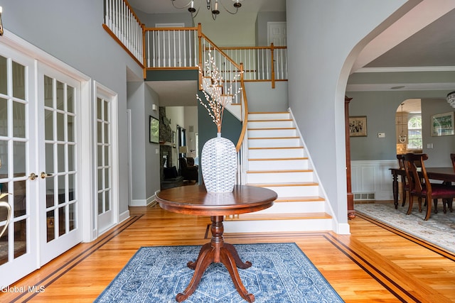 222 Bell Ct, Guilderland, NY 12303 - foyer entrance with wood finished floors, arched walkways, stairway, ornamental molding, and a chandelier