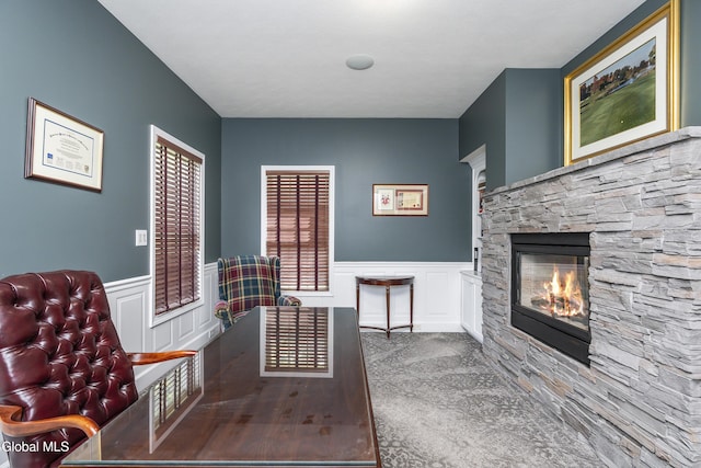 222 Bell Ct, Guilderland, NY 12303 - sitting room with a decorative wall, wainscoting, a stone fireplace, and carpet
