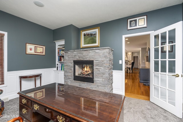 222 Bell Ct, Guilderland, NY 12303 - office with a wainscoted wall, a stone fireplace, a decorative wall, and wood finished floors