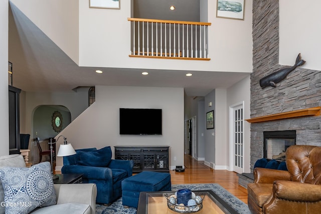 222 Bell Ct, Guilderland, NY 12303 - living room with a stone fireplace, a high ceiling, wood finished floors, recessed lighting, and arched walkways