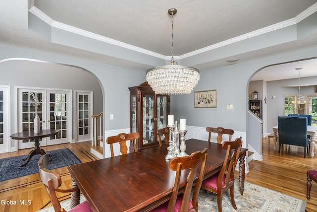 222 Bell Ct, Guilderland, NY 12303 - dining room featuring arched walkways, a chandelier, wood finished floors, crown molding, and a tray ceiling