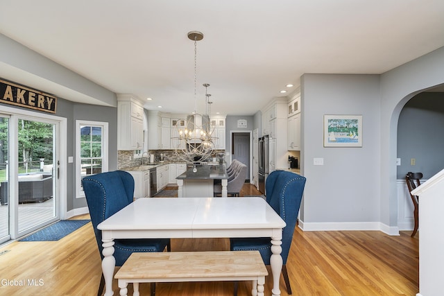 222 Bell Ct, Guilderland, NY 12303 - dining area featuring arched walkways, light wood-type flooring, a chandelier, and recessed lighting