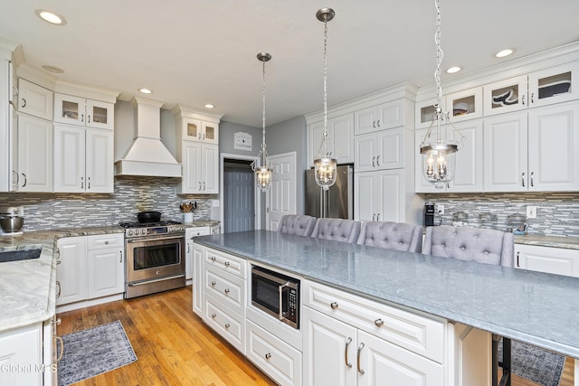 222 Bell Ct, Guilderland, NY 12303 - kitchen with appliances with stainless steel finishes, custom range hood, tasteful backsplash, white cabinetry, and recessed lighting