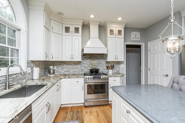222 Bell Ct, Guilderland, NY 12303 - kitchen featuring appliances with stainless steel finishes, custom exhaust hood, decorative backsplash, white cabinets, and recessed lighting