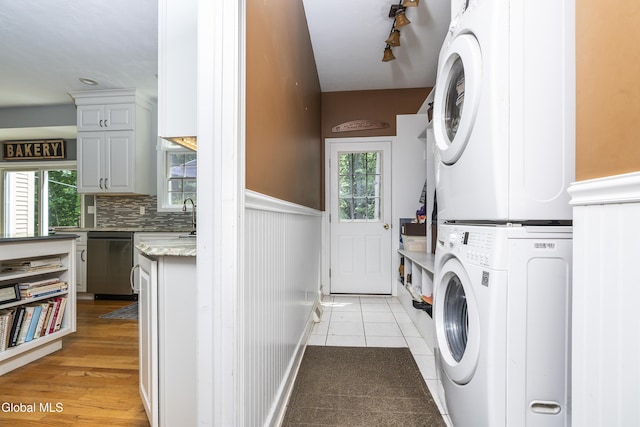 222 Bell Ct, Guilderland, NY 12303 - washroom featuring stacked washer / dryer, light tile patterned flooring, and wainscoting