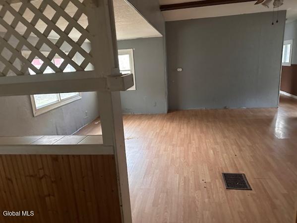 873 W Fulton Rd, Fulton, NY 12187 - unfurnished living room featuring wood finished floors and ceiling fan