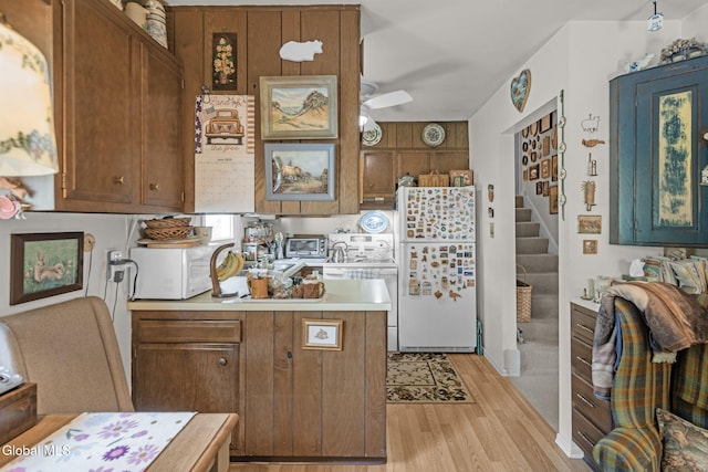 12 Jean Pl, Guilderland, NY 12303 - kitchen featuring white appliances, light wood-type flooring, a peninsula, light countertops, and brown cabinets