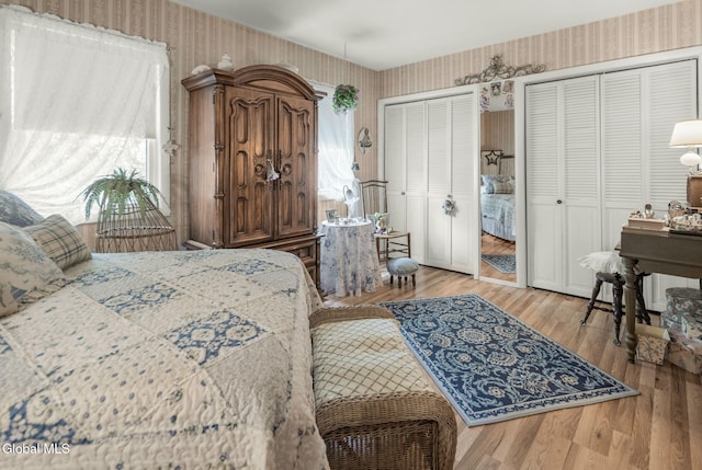 12 Jean Pl, Guilderland, NY 12303 - bedroom featuring wallpapered walls, multiple closets, multiple windows, and wood finished floors