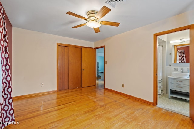 2351 Oakland Ave, Schenectady, NY 12309 - unfurnished bedroom featuring light wood-type flooring, a closet, connected bathroom, and ceiling fan