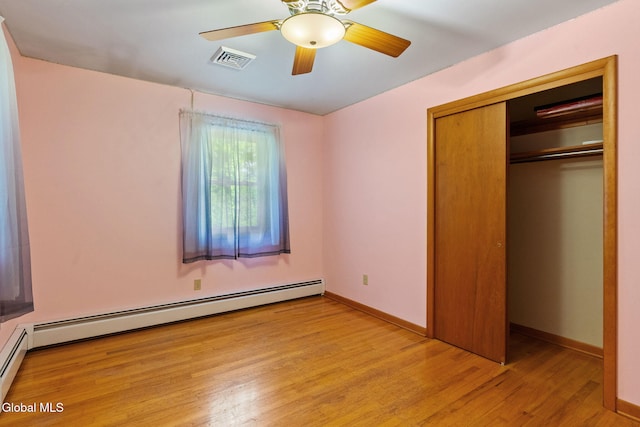 2351 Oakland Ave, Schenectady, NY 12309 - unfurnished bedroom featuring a closet, wood finished floors, a baseboard heating unit, and a ceiling fan