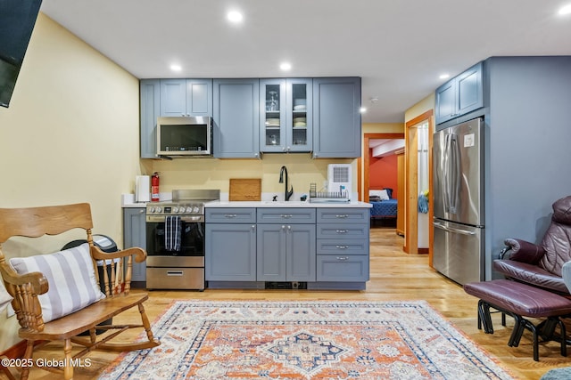 35 Scribner Hollow Rd # E3, Hunter, NY 12442 - kitchen with appliances with stainless steel finishes, light countertops, glass insert cabinets, recessed lighting, and light wood-style flooring