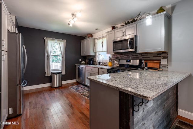 10 3rd St, South Glens Falls, NY 12803 - kitchen with stainless steel appliances, a peninsula, backsplash, and light stone counters