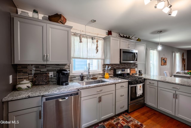 10 3rd St, South Glens Falls, NY 12803 - kitchen with stainless steel appliances, decorative backsplash, gray cabinetry, a peninsula, and dark wood-style flooring