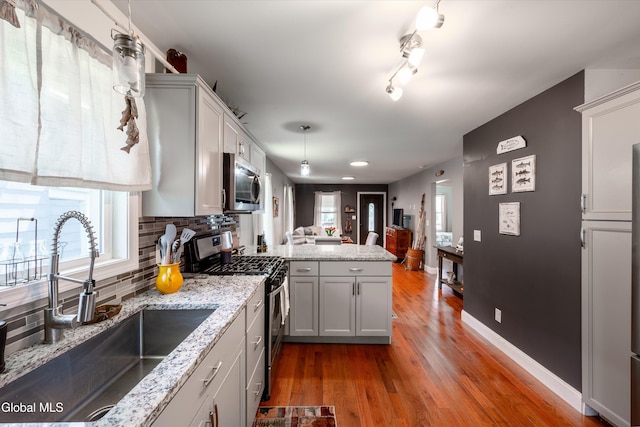 10 3rd St, South Glens Falls, NY 12803 - kitchen with stainless steel appliances, a peninsula, open floor plan, dark wood finished floors, and decorative backsplash