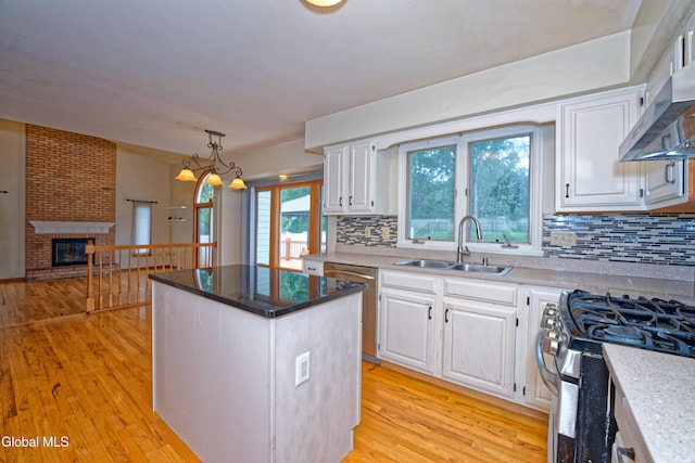 33 Cindy Ln, Halfmoon, NY 12065 - kitchen with appliances with stainless steel finishes, a center island, wall chimney range hood, light wood finished floors, and backsplash