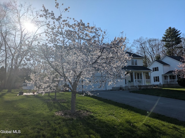 33 Cindy Ln, Halfmoon, NY 12065 - view of front of property featuring concrete driveway, covered porch, a front yard, and a garage