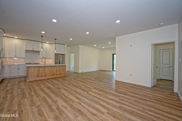 145C Bozenkill Rd, Altamont, NY 12009 - kitchen featuring appliances with stainless steel finishes, open floor plan, recessed lighting, a center island with sink, and light countertops