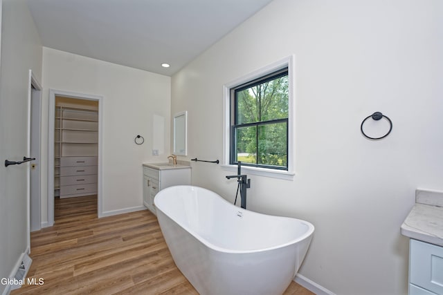 145C Bozenkill Rd, Altamont, NY 12009 - full bath featuring vanity, a freestanding bath, wood finished floors, and a walk in closet