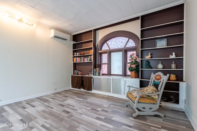 128 Circular St, Saratoga Springs, NY 12866 - living area with an AC wall unit, wood finished floors, built in features, and ornamental molding