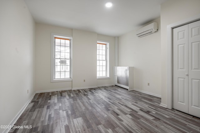 128 Circular St, Saratoga Springs, NY 12866 - unfurnished bedroom featuring an AC wall unit, wood finished floors, and a closet