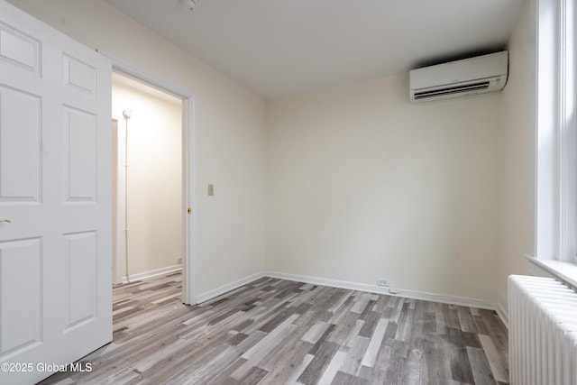 128 Circular St, Saratoga Springs, NY 12866 - empty room with radiator, a wall unit AC, and light wood-type flooring