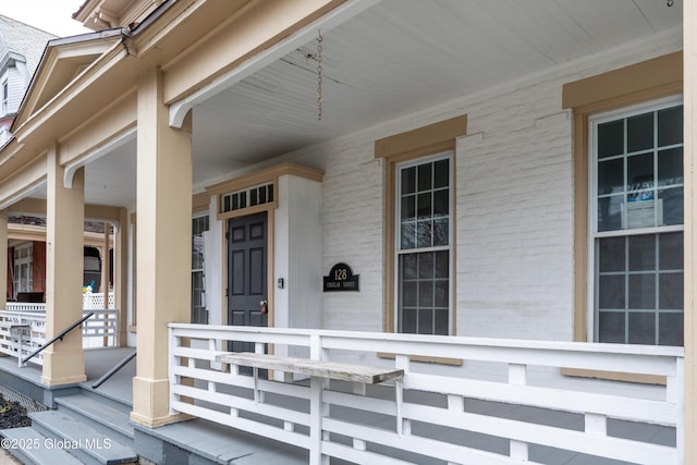 128 Circular St, Saratoga Springs, NY 12866 - doorway to property featuring covered porch and brick siding